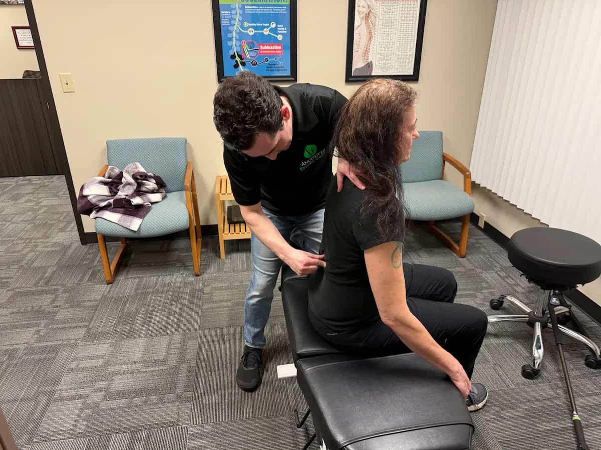Chiropractor performing spinal adjustment on patient