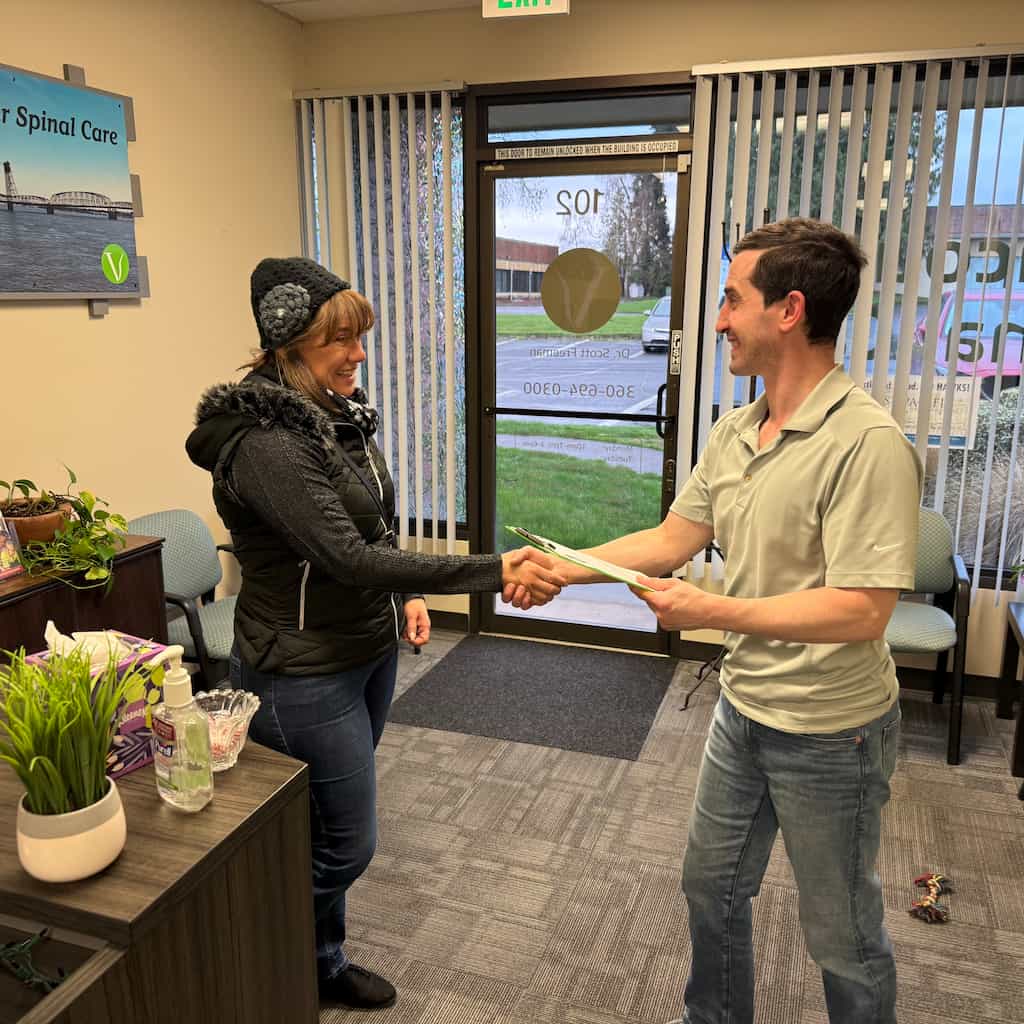 Dr. Scott Freeman greeting a patient inside Vancouver Spinal Care chiropractic clinic