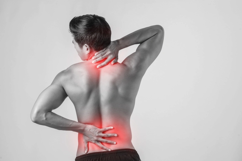 Man standing with lower back pain in black and white image