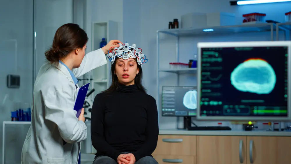 Woman undergoing nervous system scan with monitoring device on head