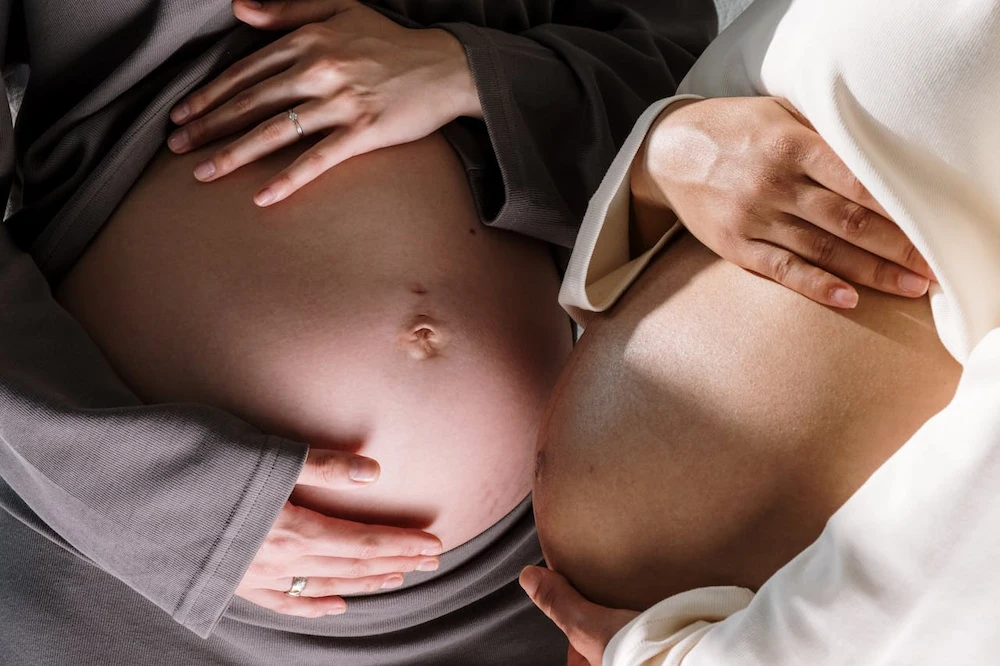 pregnant women touching bellies during maternity moment