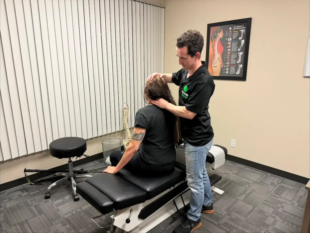 Chiropractor performing neck adjustment on patient