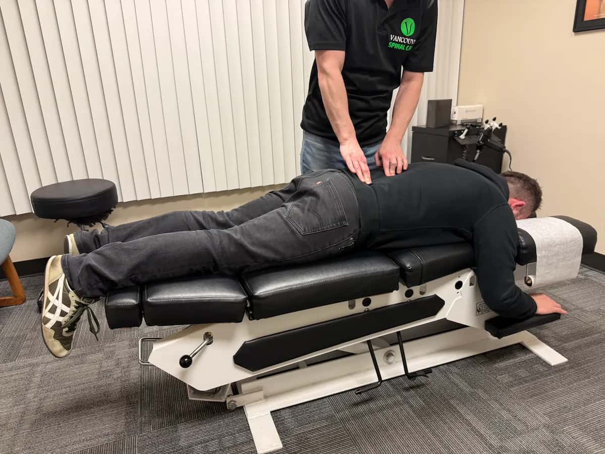 Chiropractor performing lumbar adjustment