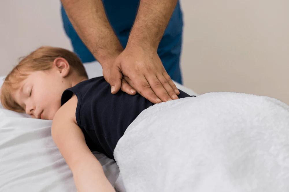 chiropractor performing back treatment on child