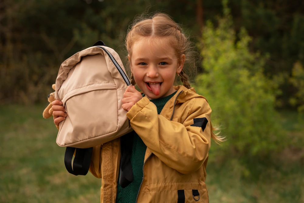 Child carrying heavy backpack showing signs of back strain