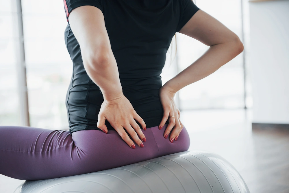 Person experiencing lower back and leg pain from sciatica or piriformis syndrome