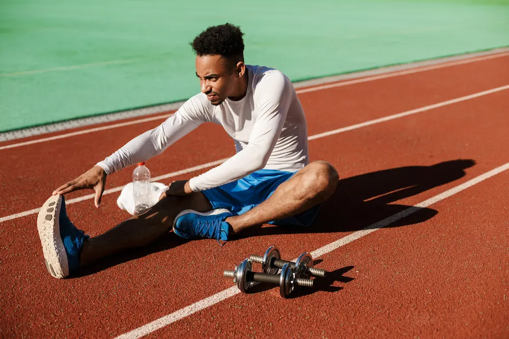 Athlete stretching muscles before workout to improve flexibility and prevent injury