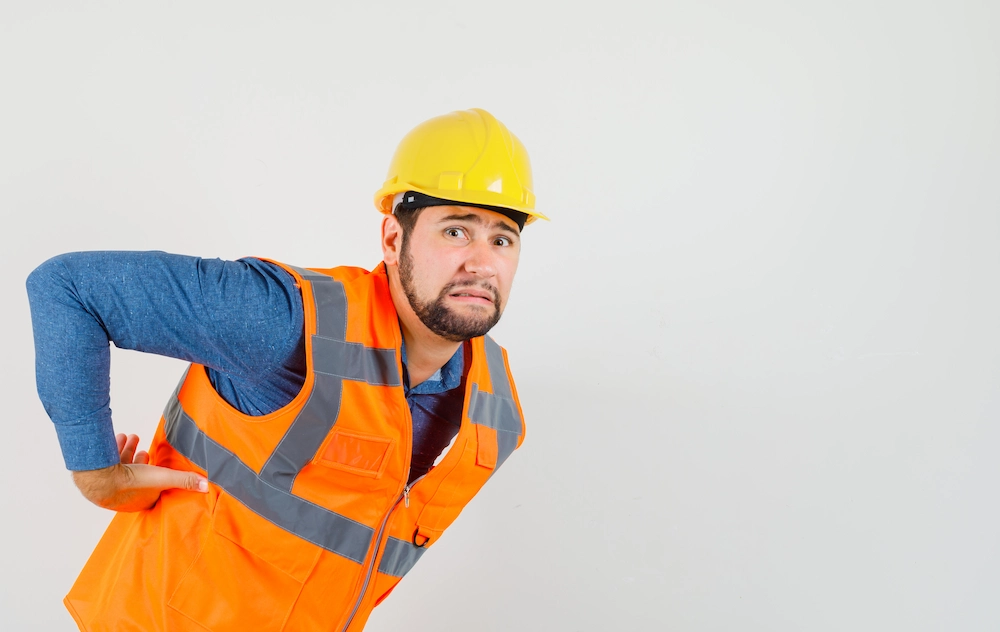 Construction worker stretching their back after physical labor